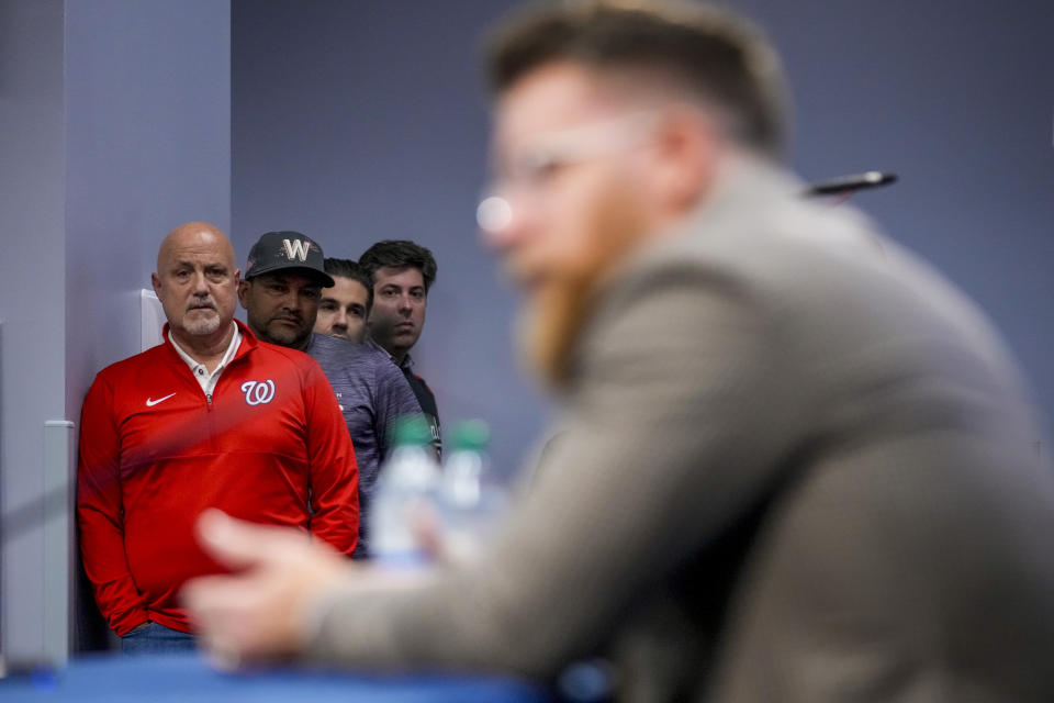 Washington Nationals general manager Mike Rizzo, left, and Washington Nationals manager Dave Martinez, second from left, watch as Washington Nationals relief pitcher Sean Doolittle, foreground, speaks at a news conference after announcing his retirement at Nationals Park, Friday, Sept. 22, 2023, in Washington. Doolittle has decided to retire from baseball after more than a decade pitching in the majors that included helping the Nationals win the World Series in 2019. (AP Photo/Andrew Harnik)