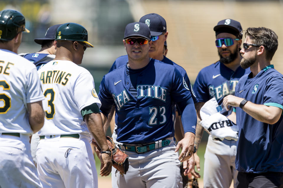 Seattle Mariners first baseman Ty France (23) leaves the field after he sustained an injury as Oakland Athletics' Sheldon Neuse, far left, reached first base on a single during the fifth inning of a baseball game in Oakland, Calif., Thursday, June 23, 2022. (AP Photo/John Hefti)