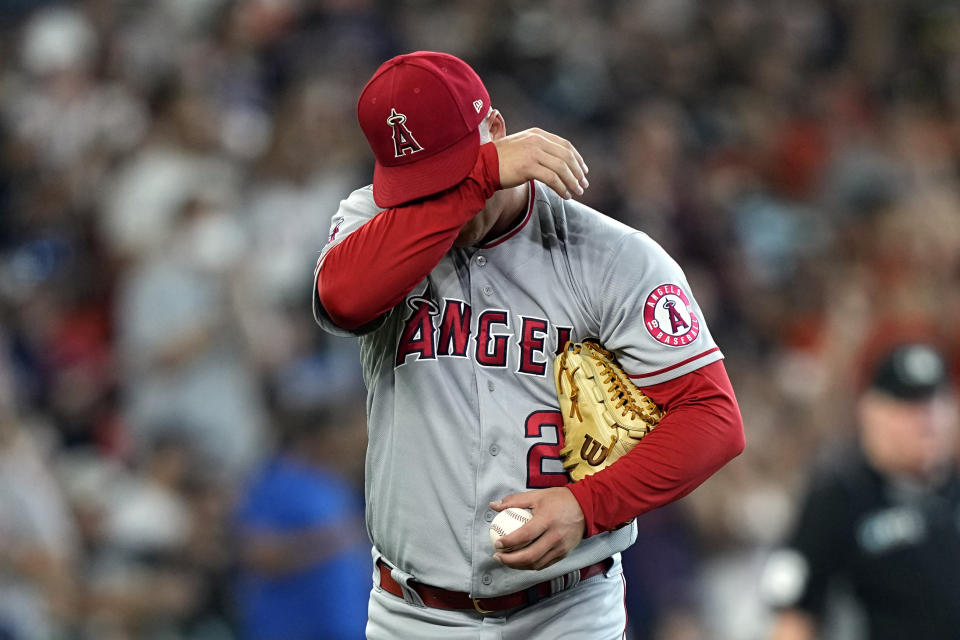 Los Angeles Angels relief pitcher Aaron Loup wipes his face after giving up a home run to Houston Astros' Chas McCormick during the seventh inning of a baseball game Saturday, July 2, 2022, in Houston. (AP Photo/David J. Phillip)