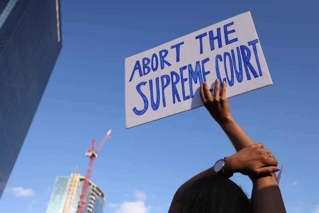 A protester holds up a sign as she takes part in a Rally to Defend Abortion Rights after the Supreme Court announced its decision to overturn Roe v. Wade in Boston on June 24, 2022. (Photo by Jessica Rinaldi/The Boston Globe via Getty Images)