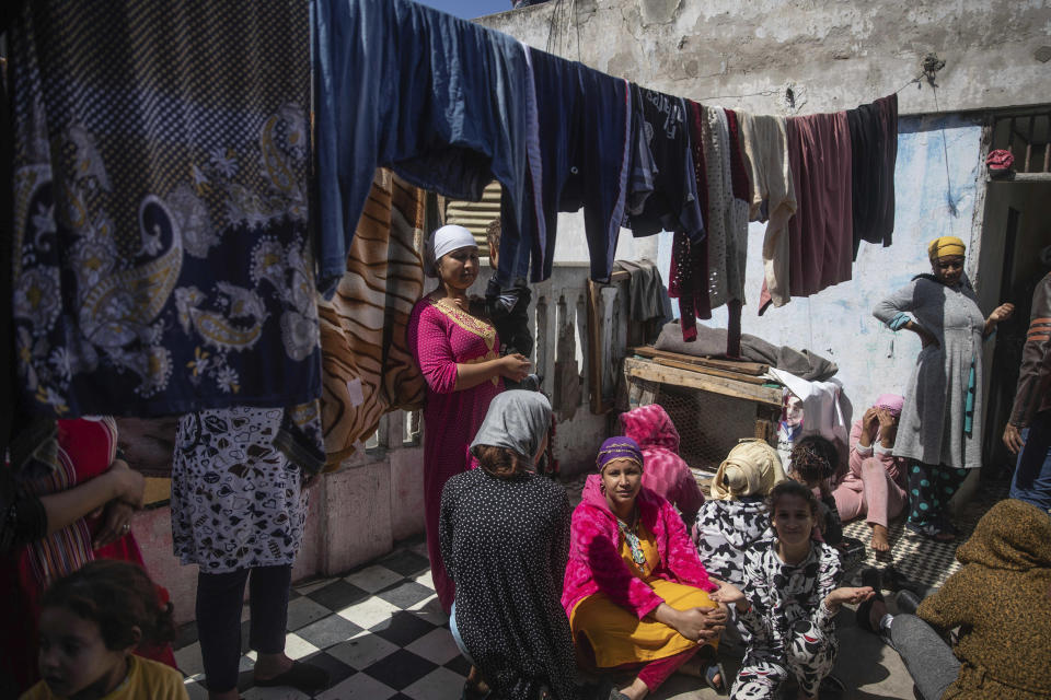 In this in Wednesday, March 25, 2020 photo, women gather in an overcrowded housing complex in Sale, near Rabat, Morocco. Hundreds of people live in crowded rooms in this Moroccan housing complex with no running water and no income left because of the coronavirus lockdown measures. However volunteers come to help clean as the government tries to protect the population from virus while not punishing the poor. (AP Photo/Mosa'ab Elshamy)