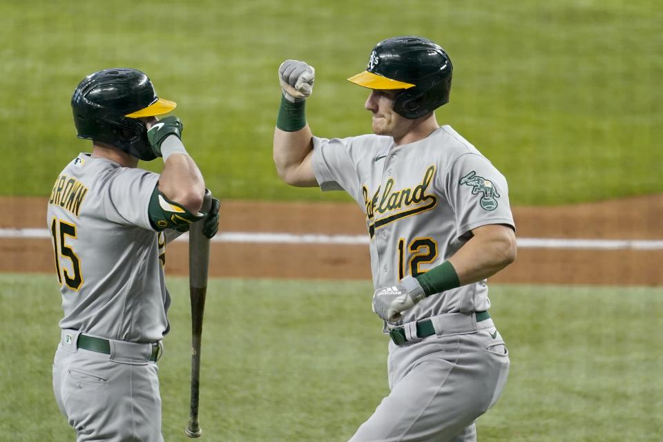 Oakland Athletics' Seth Brown (15) and Sean Murphy (12) celebrate a solo home run hit by Murphy in the second inning of a baseball game against the Texas Rangers in Arlington, Texas, Saturday, July 10, 2021. (AP Photo/Tony Gutierrez)