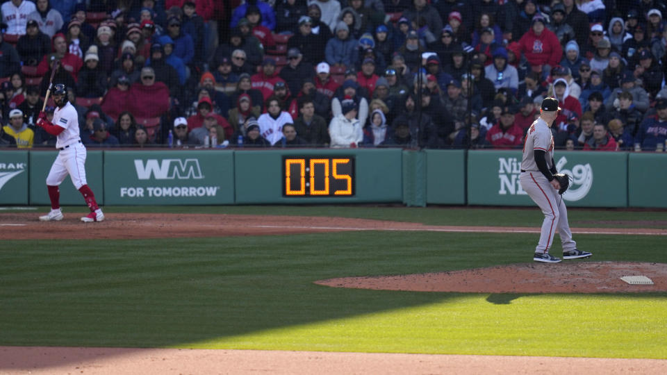 Baltimore Orioles relief pitcher Logan Gillaspie, right, starts to deliver a pitch to Boston Red Sox's Connor Wong, as the pitch clock ticks to five seconds, during the eighth inning of an opening day baseball game at Fenway Park, Thursday, March 30, 2023, in Boston. (AP Photo/Charles Krupa)