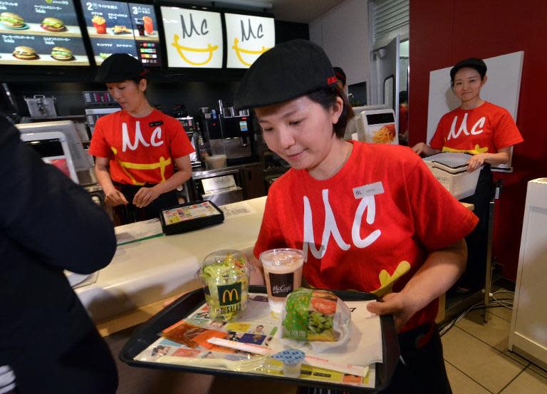 A McDonald's employee serves a "Vegetable Chicken Burger" as a new menu is unveiled in Tokyo on May 21, 2015