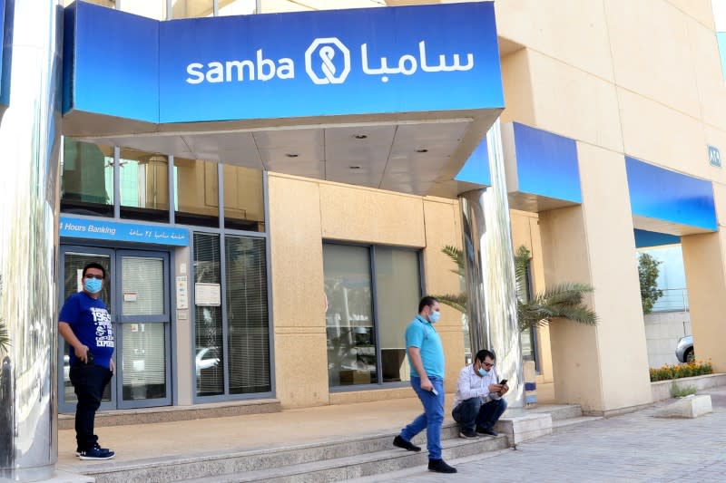 People wearing protective face masks are seen outside Samba bank as the government eases lockdown restrictions amid the coronavirus disease (COVID-19) outbreak, in Riyadh