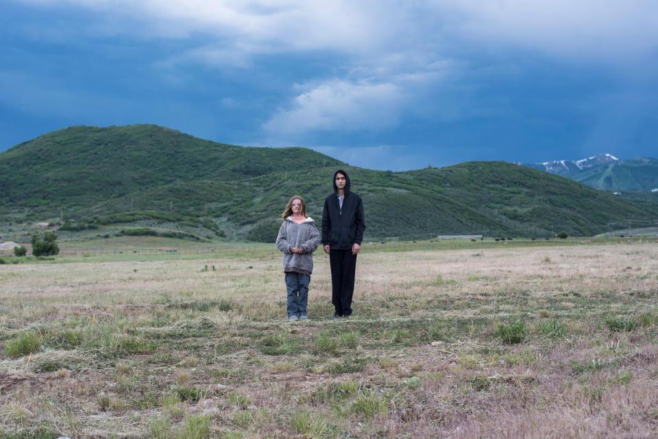 Peter and his little sister walking in a field