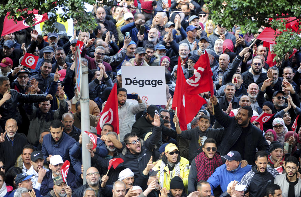 Tunisians gather during a protest against Tunisian President Kais Saied in downtown Tunis, Tunisia, Saturday Jan. 14, 2023. Tunisians mark 12 years since Tunisian protesters unleashed Arab Spring uprisings around the region. The protest comes after disastrous parliamentary elections last month in which just 11% of voters cast ballots. It also comes as the country is going through a major economic crisis, with inflation and joblessness on the rise. The banner in French reads: "leave." (AP Photo/Hassene Dridi)