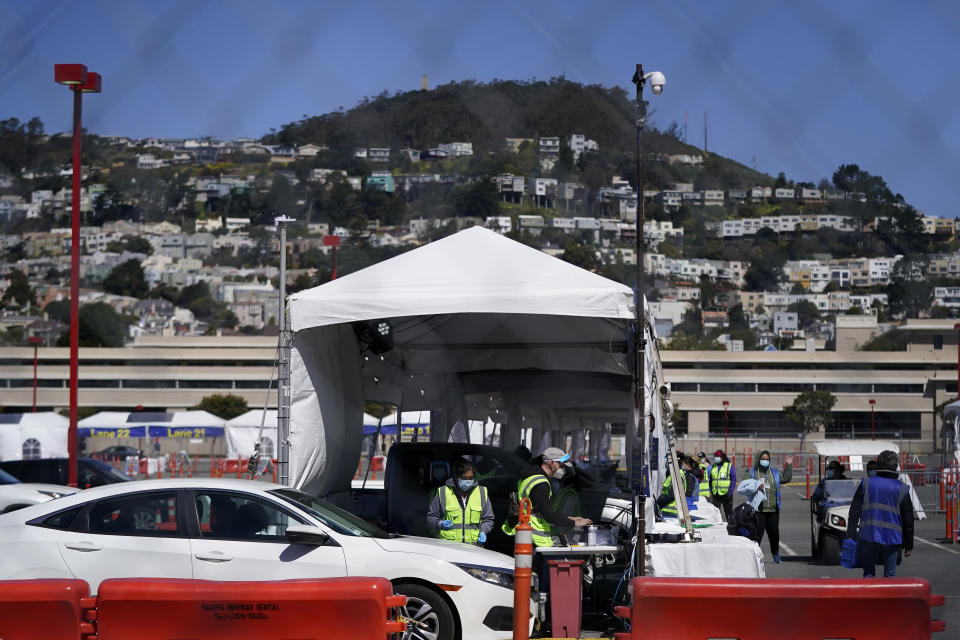 Healthcare workers tend to people in cars at a drive up vaccination center at City College of San Francisco during the coronavirus pandemic in San Francisco, Thursday, March 25, 2021. (AP Photo/Jeff Chiu)