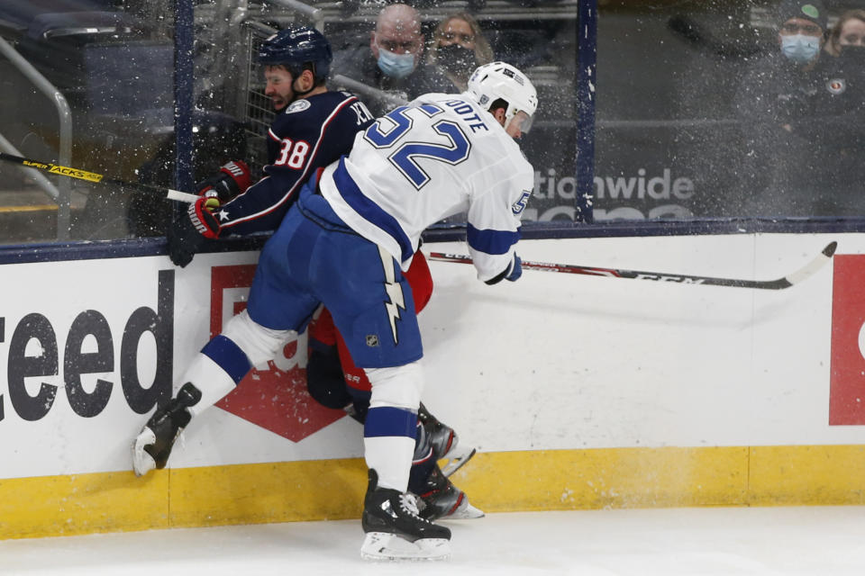Tampa Bay Lightning's Callan Foote, right, checks Columbus Blue Jackets' Boone Jenner during the second period of an NHL hockey game Saturday, Jan. 23, 2021, in Columbus, Ohio. (AP Photo/Jay LaPrete)