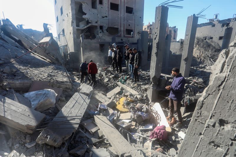 Palestinians inspect the site of an Israeli strike on a residential building, at Nuseirat refugee camp in central Gaza Strip