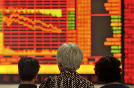 Investors look at an electronic board showing stock information at a brokerage house in Fuyang, Anhui province, China, June 26, 2015. REUTERS/China Daily