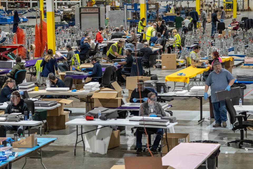 People work on assembling protective face shields at Troy Manufacturing Design a Ford subsidiary in Plymouth on Friday, March 27, 2020. Ford, in cooperation with the UAW, will assemble more than 100,000 critically needed plastic face shields per week to help medical professionals, factory workers and store clerks.
 