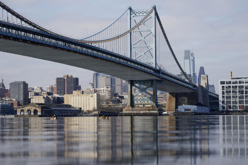 FILE - This Feb. 10, 2021 file photo shows the Philadelphia side of the Benjamin Franklin Bridge spanning the Delaware River. The Delaware River Basin Commission voted Thursday, Feb. 25, 2021, to permanently ban natural gas drilling and fracking because it poses too great of a risk to the the river and its tributaries that supply drinking water to Philadelphia and half the population of New York City. The ban applies to two counties in Pennsylvania's northeastern tip that are part of the nation's largest gas field, the Marcellus Shale. (AP Photo/Matt Rourke, File)