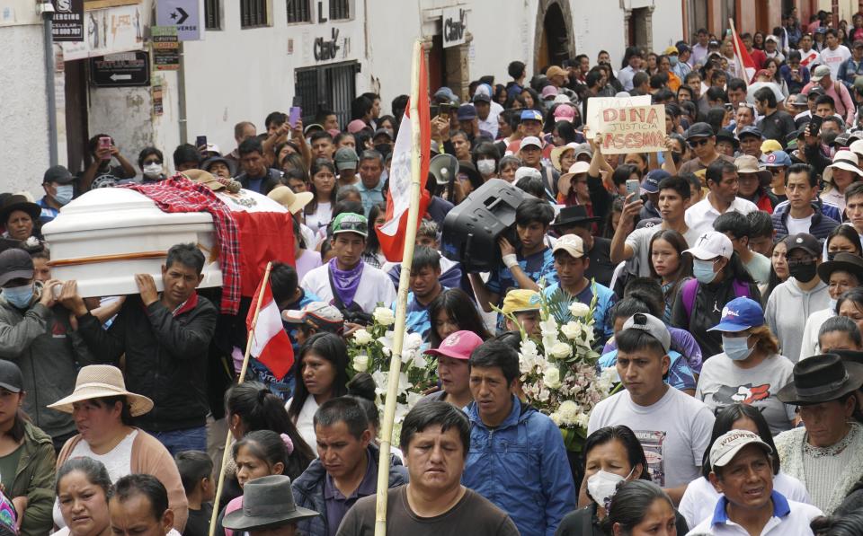 People attend the funeral procession of Clemer Rojas, 23, who was killed during protests against new President Dina Boluarte, in Ayacucho, Peru, Saturday, Dec. 17, 2022. The eight deaths this week that converted Ayacucho into the epicenter of violence in Peru's still unfolding crisis is for many a stark reminder of the region's bloody past and longstanding neglect by authorities in the far-away capital. (AP Photo/Franklin Briceno)