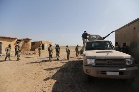 Turkey-backed Syrian rebel fighters stand near a truck mounted with a weapon, near the border town of Tel Abyad