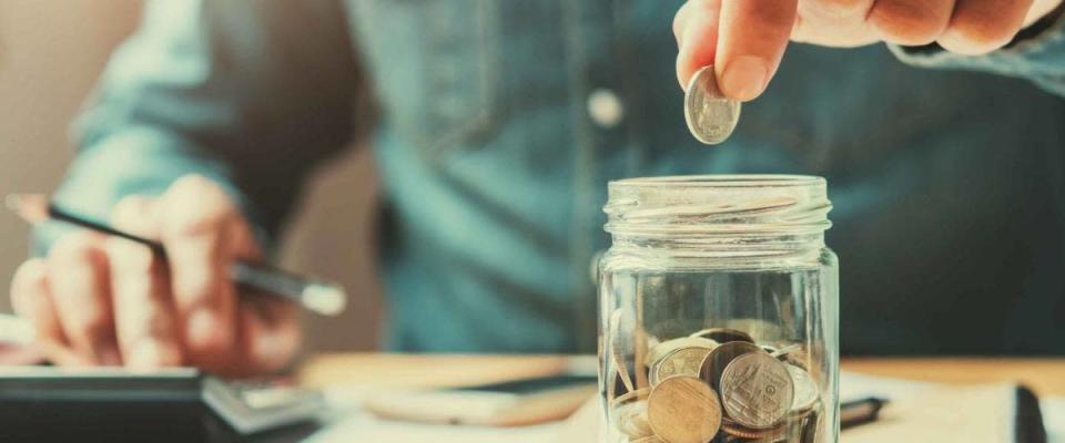 businessman holding coins putting in glass. concept saving money for finance accounting