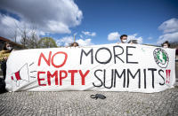 Activists from the environmental group Fridays for Future demonstrated in Invalidenpark with a banner reading "No more empty summits" in Berlin, Germany, Friday, April 23, 2021. On the occasion of the US climate summit with 40 invited countries, the climate activists demand immediate action against climate change. (Fabian Sommer/dpa via AP)