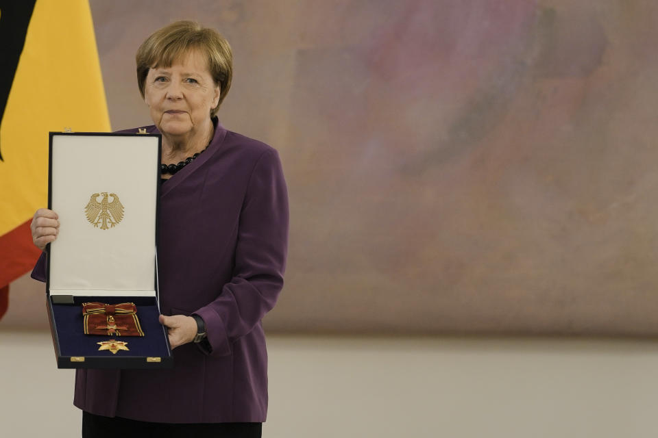 Former Chancellor Angela Merkel poses with the Grand Cross of the Order of Merit of the Federal Republic of Germany in a special design to during a reception at Bellevue Palace in Berlin, Germany, Monday, April 17, 2023. (AP Photo/Markus Schreiber)