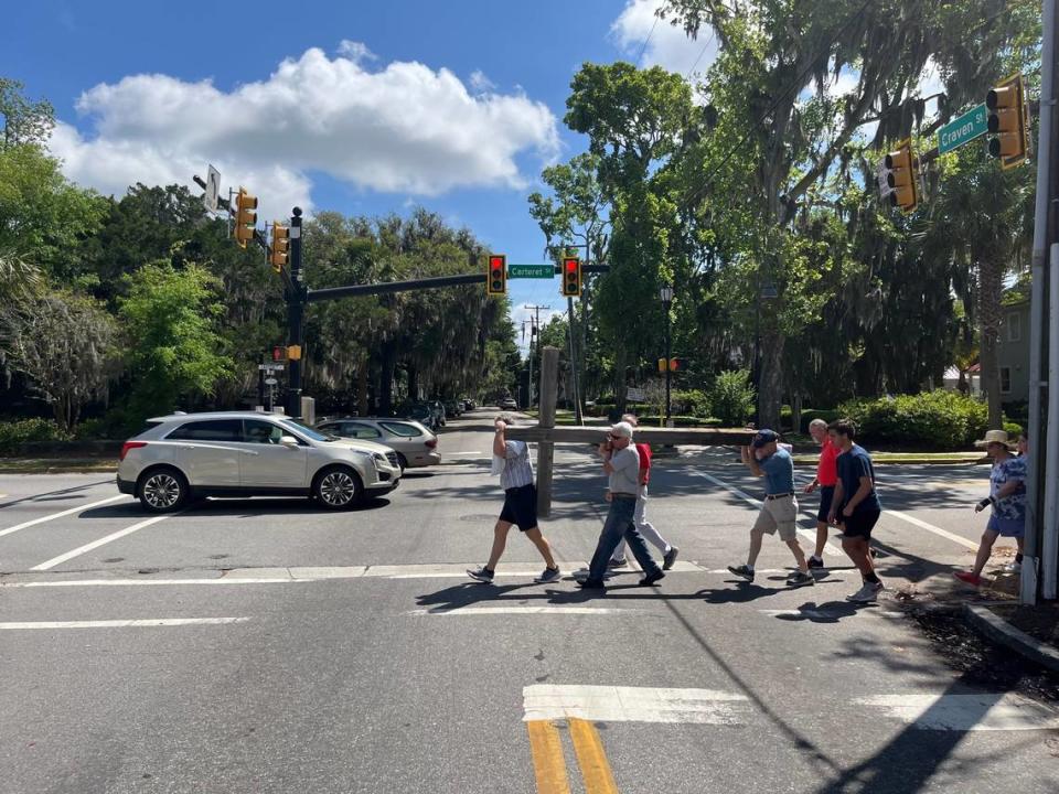 Members of United Methodist Church carry a cross through the intersection of Craven and Carteret streets to mark Good Friday.