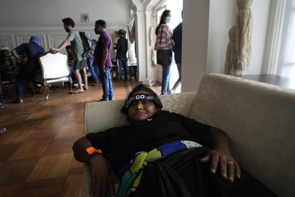 A protester rests on a sofa in the living hall of prime minister's official residence a day after vandalising it in Colombo, Sri Lanka, Sunday, July 10, 2022. Sri Lanka’s opposition political parties will meet Sunday to agree on a new government a day after the country’s president and prime minister offered to resign in the country’s most chaotic day in months of political turmoil, with protesters storming both officials’ homes and setting fire to one of the buildings in a rage over the nation’s economic crisis. (AP Photo/Eranga Jayawardena)