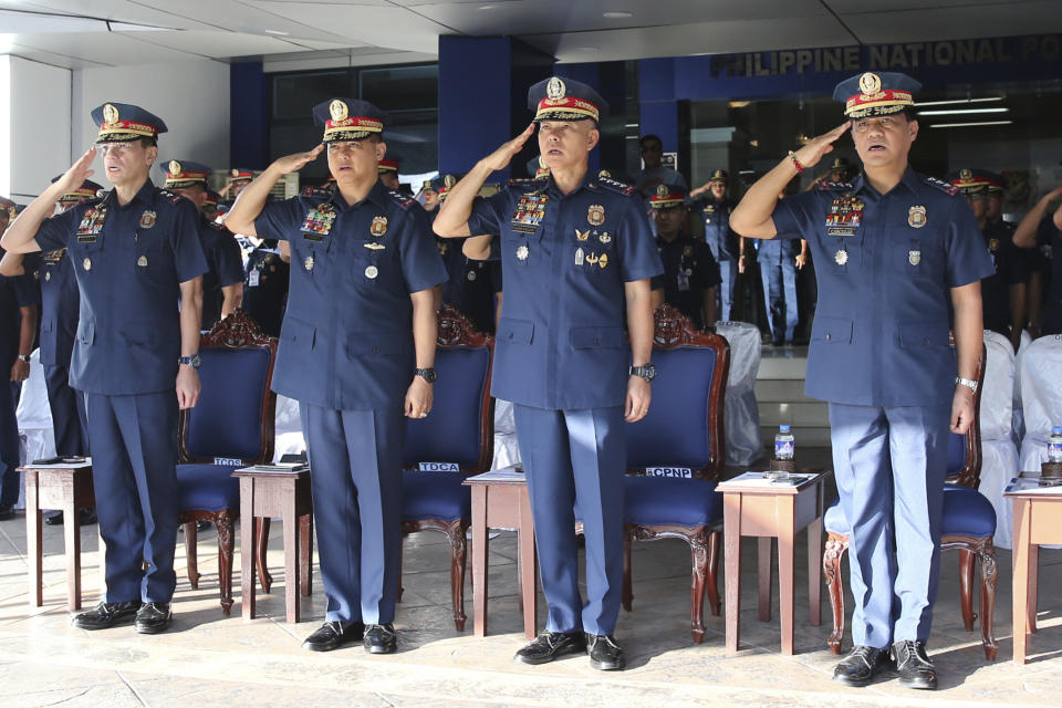 In this photo provided by Philippine National Police Public Information Office, Philippine National Police chief Gen. Oscar Albayalde, second from right, along with top police generals, Lt.Gen. Camilo Cascolan, right, Lt.Gen. Archie Gamboa, second from left, and Maj.Gen. Guillermo Eleazar, left, salutes during the flag-raising ceremony at Camp Crame Monday, Oct. 14, 2019 in suburban Quezon city, northeast of Manila, Philippines. Albayalde resigned on Monday after he faced allegations in a Senate hearing that he intervened as a provincial police chief in 2013 to prevent his officers from being prosecuted for allegedly selling a huge quantity of illegal drugs they had seized. (Philippine National Police Via AP)