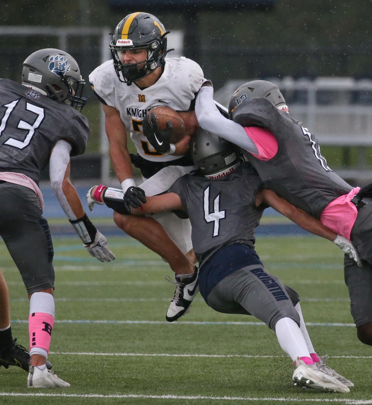 McQuaid running back John Harding hurdles through a trio of Brighton defenders, Gavin Parks, Noah Wagner and Kaleb Matthews for a big gain up the middle during their Section V contest Saturday, Oct. 14, 2023 at Brighton High School. McQuaid won the close matchup 32-31 in overtime.