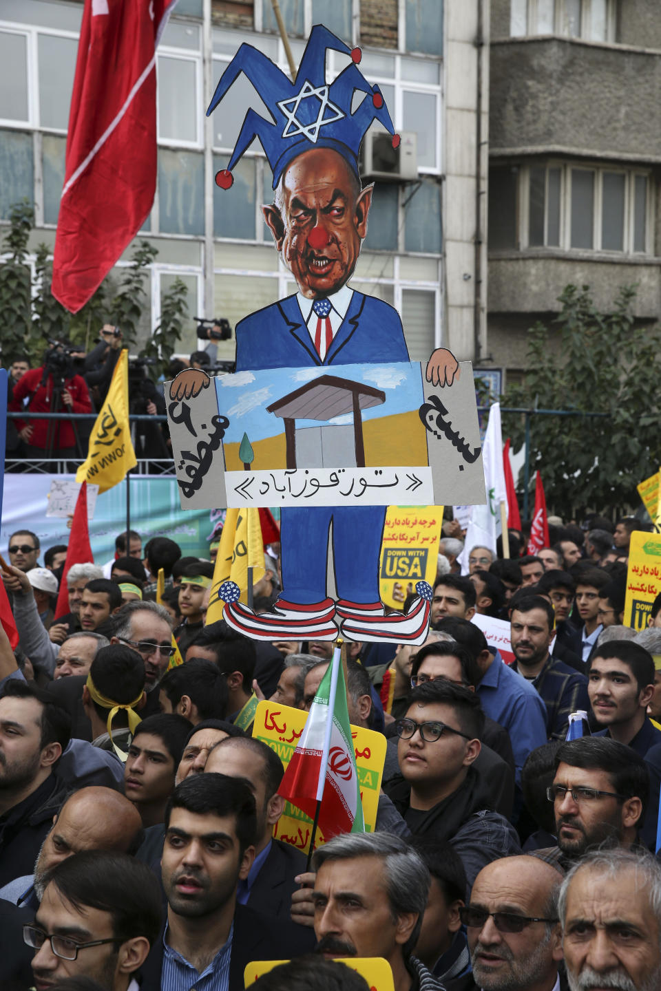 A demonstrator holds up a caricature of Israeli Prime Minister Benjamin Netanyahu during a rally in front of the former U.S. Embassy in Tehran, Iran, on Sunday, Nov. 4, 2018, marking the 39th anniversary of the seizure of the embassy by militant Iranian students. Thousands of Iranians rallied in Tehran on Sunday to mark the anniversary as Washington restored all sanctions lifted under the nuclear deal. (AP Photo/Vahid Salemi)
