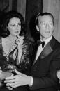 <p>The designer’s social circle was famously star-studded. He’s pictured here at an event with Elizabeth Taylor.</p>