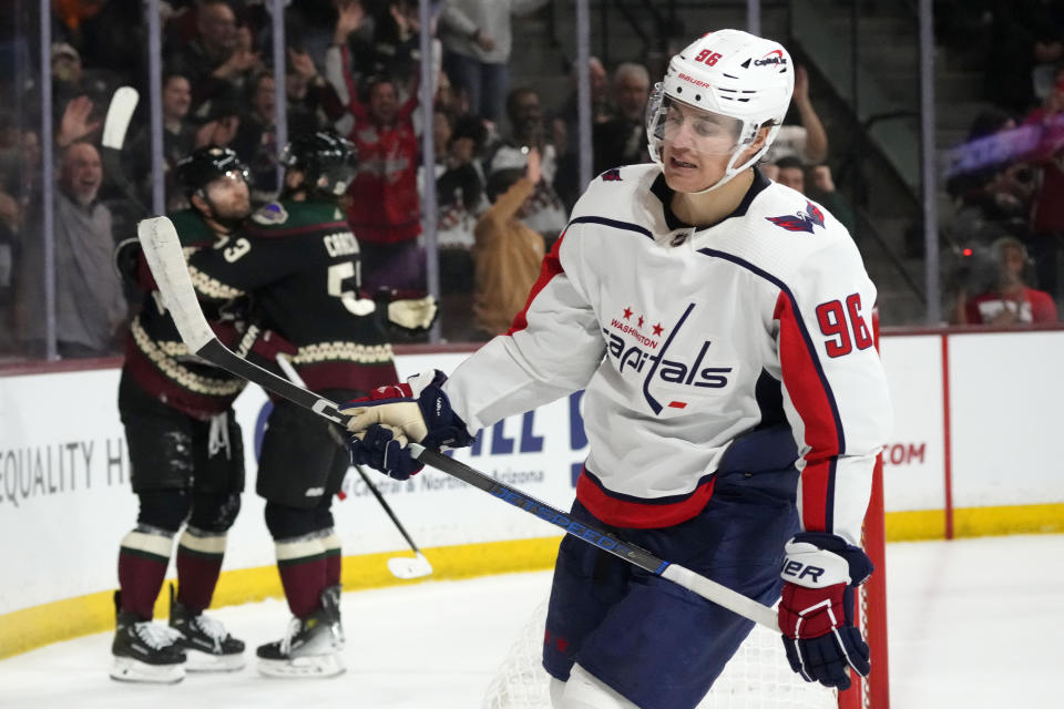 Washington Capitals right wing Nicolas Aube-Kubel (96) skates away as Arizona Coyotes left wing Jason Zucker, back left, celebrates after making a goal with left wing Michael Carcone during the first period of an NHL hockey game Monday, Dec. 4, 2023, in Tempe, Ariz. (AP Photo/Ross D. Franklin)