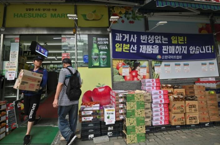 A blue banner (top R) outside a grocery shop in Seoul reads 'Japan - a country that does not regret its past. We do not sell Japanese products here' (AFP Photo/Jung Yeon-je)