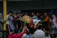 Kashmiri villagers carry the body of Sunil Kumar, a Kashmiri Hindu man locally known as Pandit, outside his home at Chotigam village, some 62 kilometers south of Srinagar, Indian controlled Kashmir, Tuesday, Aug. 16, 2022. Pandit was shot dead by suspected rebels at an apple orchard on Tuesday morning, while his brother was injured in the attack, officials said. (AP Photo/Mukhtar Khan)