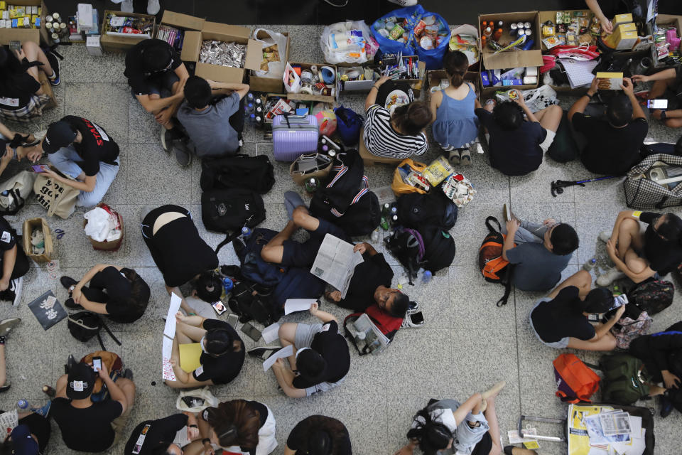 Thousands take part in a second day of sit-in protest at the airport in Hong Kong on Saturday, Aug. 10, 2019. Hong Kong is in its ninth week of demonstrations that began in response to a proposed extradition law but have expanded to include other grievances and demands for more democratic freedoms. (AP Photo/Kin Cheung)