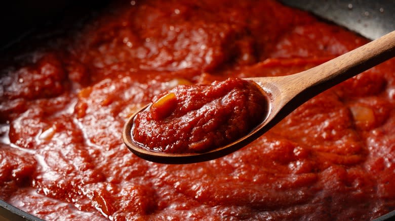 Cooking ketchup with wooden spoon