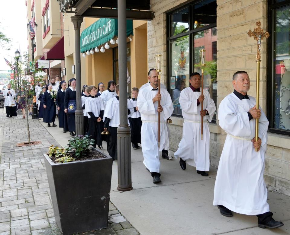 Clergy lead the way, marching with parishioners through downtown Waukesha along the Waukesha Christmas Parade route, in remembrance of the 2021 Christmas parade attack, as part of the National Eucharistic Pilgrimage, traveling through southeast Wisconsin in Waukesha, June 21, 2024. The Archdiocese of Milwaukee hosted the group traveling with Jesus in the Blessed Sacrament to the 10th National Eucharistic Congress in Indianapolis, Indiana July 17-21.