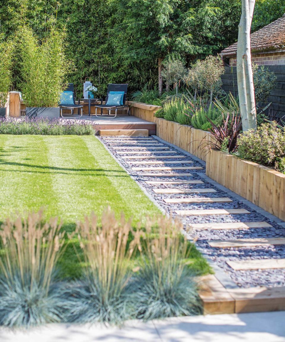 <p> Garden paths tend to be a crucial factor in a landscaping design, leading the way from A to B. And there are plenty of ways to get creative with them – from the shape and form they take to the materials you use.  </p> <p> Think about the effect different types of paths will have on the way you move across your plot. A meandering, stepping stone pathway around flower beds feels relaxed and will encourage a sense of play, for instance. Meanwhile, a sleek, paved walkway with recessed lights is a practical solution for areas of heavy traffic – perfect as a front yard landscaping idea. </p> <p> This example provides easy access to the raised beds and decked zone, without the need to walk on the lawn (handy for when it's raining or frosty). It looks great too – we love the mix of timber sleepers and gravel with the smart stone edge. And tucking it to the side is a wise move – positioning a path right down the middle of your plot is a common landscaping mistake that is seldom practical. </p>