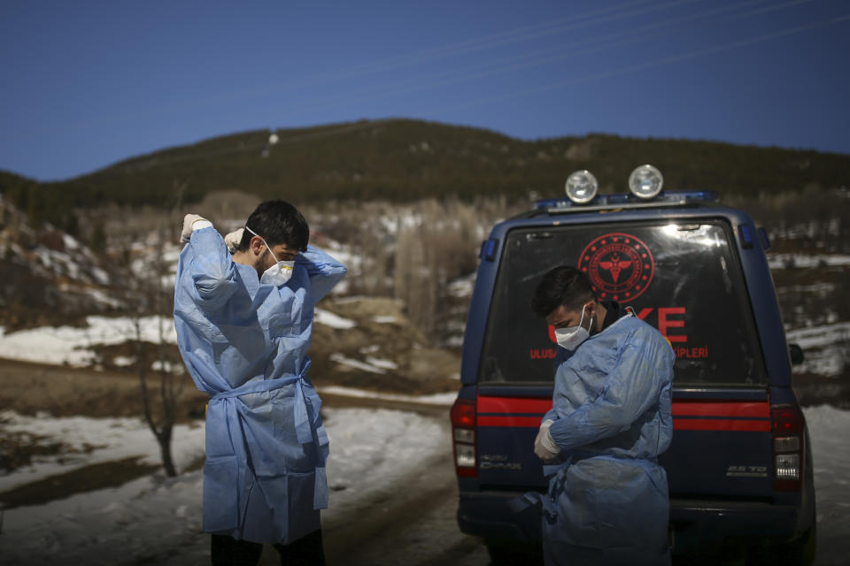 Dr. Yasin Kaya, left and health worker Yusuf Duran, right, members of the the Koyulhisar Public Health Center vaccination team, prepare to vaccinate 85-year-old Ibrahim Yigit in the isolated village of Gumuslu in the district of Sivas, central Turkey, Friday, Feb. 26, 2021. (AP Photo/Emrah Gurel)