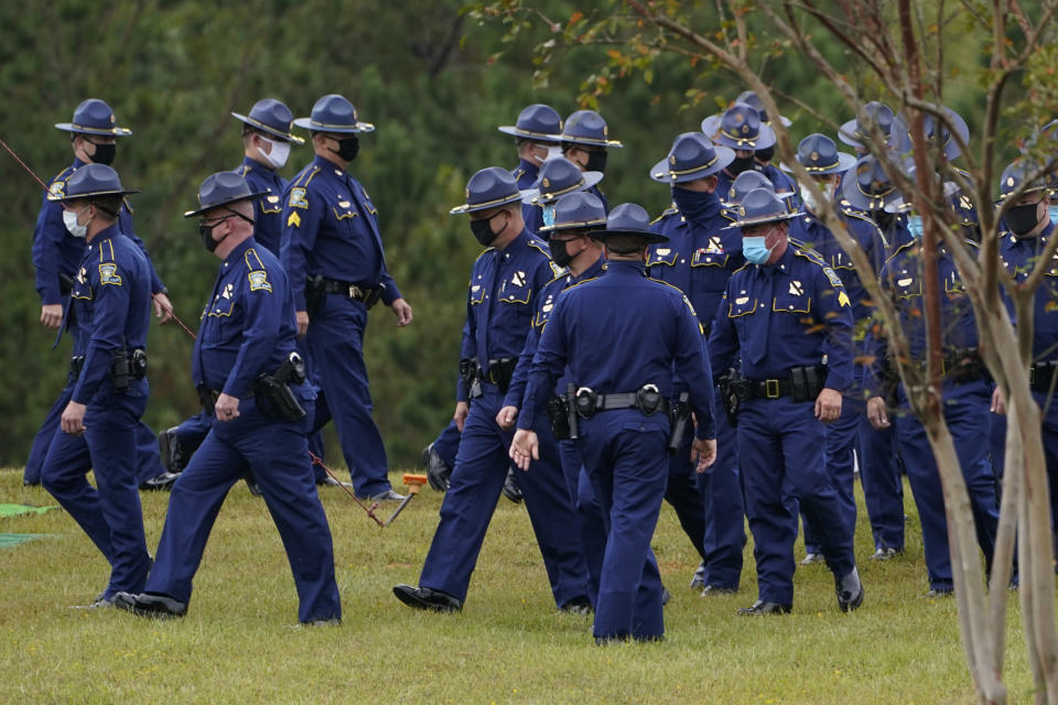FILE - In this Friday, Sept. 25, 2020, file photo, troopers of the Louisiana State Police gather at the burial site of Master Trooper Chris Hollingsworth, in West Monroe, La. Hollingsworth died in a single-car crash hours after he learned he had been fired for his role in the in-custody death of Ronald Greene. As the Louisiana State Police reel from a sprawling federal investigation into the deadly 2019 arrest of Greene, a Black motorist, and other beating cases, dozens of current and former troopers tell The Associated Press of an entrenched culture at the agency of impunity, nepotism and in some cases outright racism. (AP Photo/Rogelio V. Solis, File)