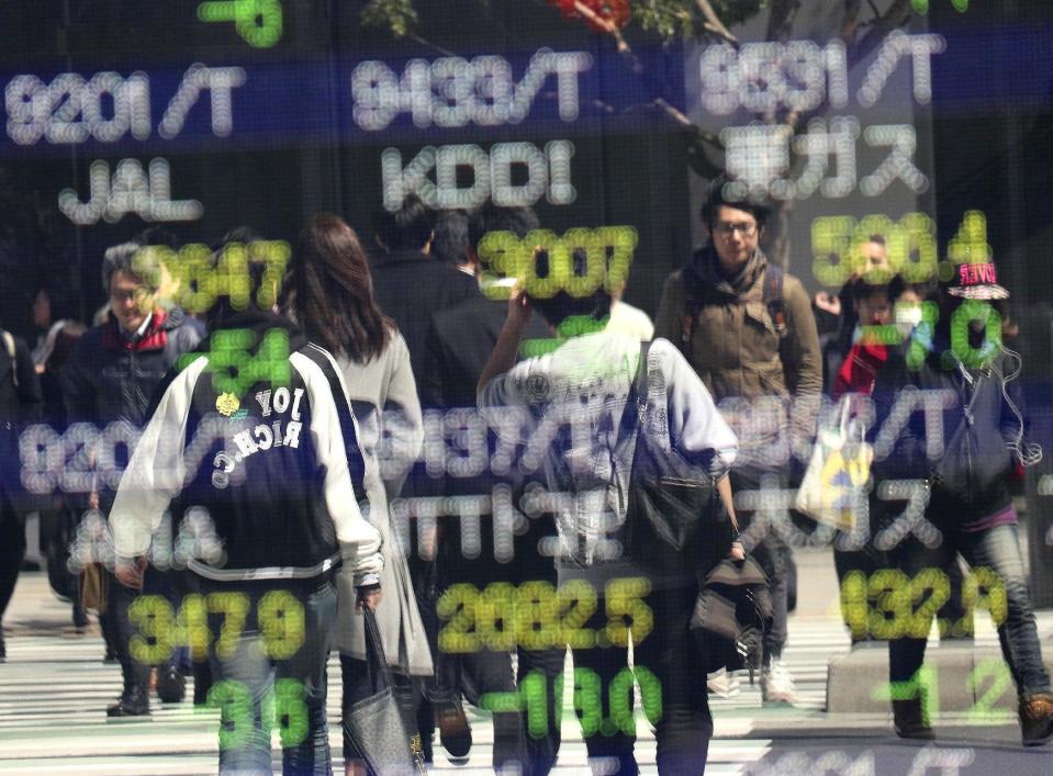 People are reflected on an electronic stock indicator of a securities firm in Tokyo, Wednesday, March 22, 2017. Shares fell in Asia early Wednesday after U.S. stocks took their biggest loss in five months. The sell-off overnight on Wall Street was spurred by obstacles to a health care bill backed by President Donald Trump that also raised questions over prospects for his agenda of boosting growth by cutting taxes and regulations. (AP Photo/Shizuo Kambayashi)