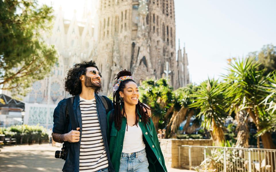 Smiling couple walking around Sagrada Familia church at Barcelona, Catalonia, Spain