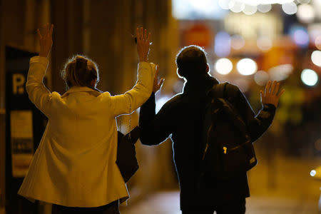 People raise their arms to show their hands as they walk towards police on a side road near the Champs Elysees Avenue after a shooting incident in Paris, France. REUTERS/Benoit Tessier