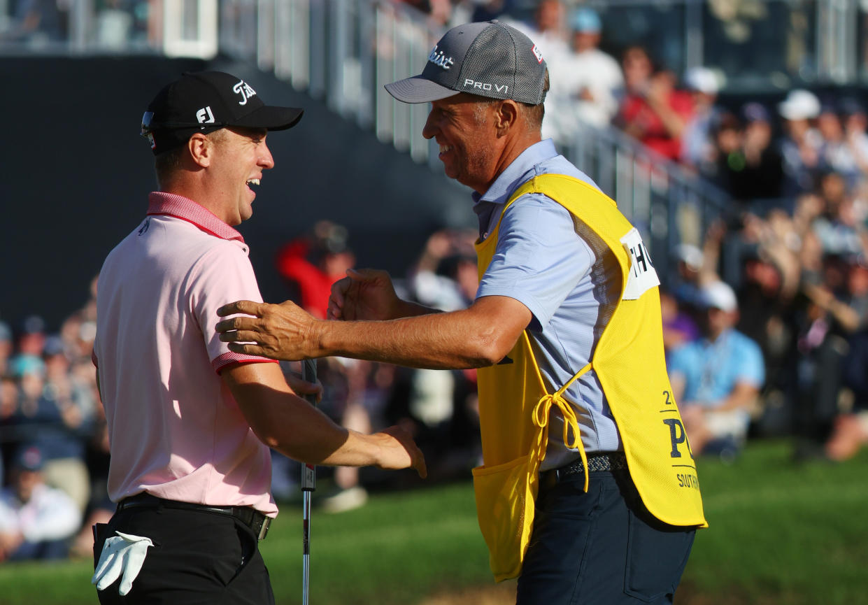 TULSA, OKLAHOMA - MAY 22: Justin Thomas of the United States reacts to his winning putt on the 18th hole with caddie Jim 