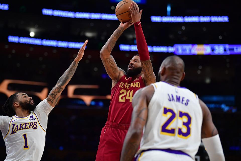 Cavaliers forward Marcus Morris Sr. over Lakers guard D'Angelo Russell (1) and forward LeBron James during the first half, April 6, 2024, in Los Angeles.