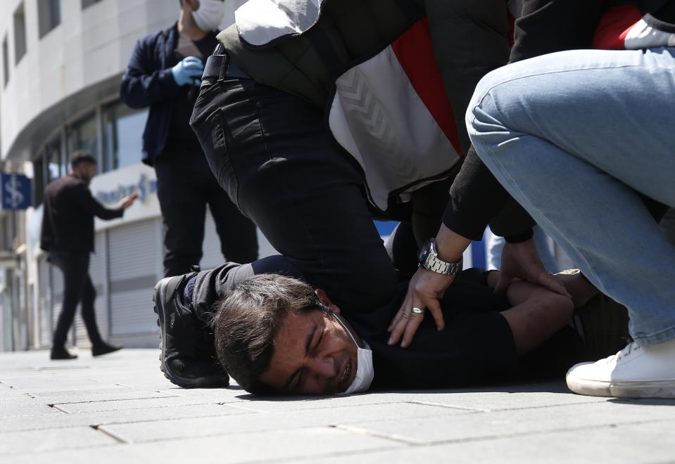 FILE - In this May 1, 2020, file photo, Turkish police officers arrest a demonstrator wearing a face mask for protection against the coronavirus, during May Day protests near Taksim Square, in Istanbul. The death of George Floyd has renewed scrutiny of immobilization techniques long used in policing around the world. (AP Photo/Emrah Gurel, File)