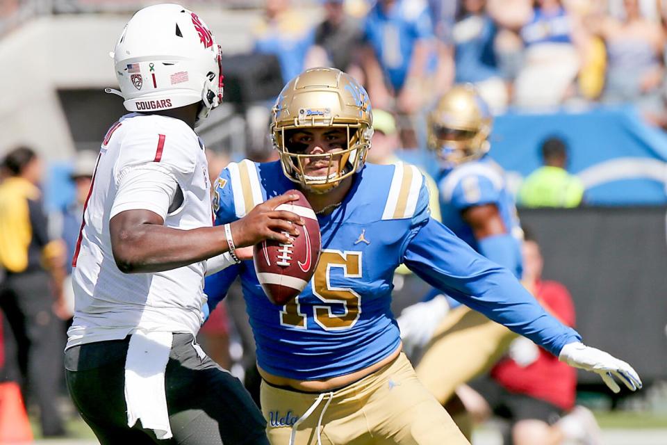 UCLA defensive end Laiatu Latu runs toward Washington State quarterback Cameron Ward, who is looking to pass.