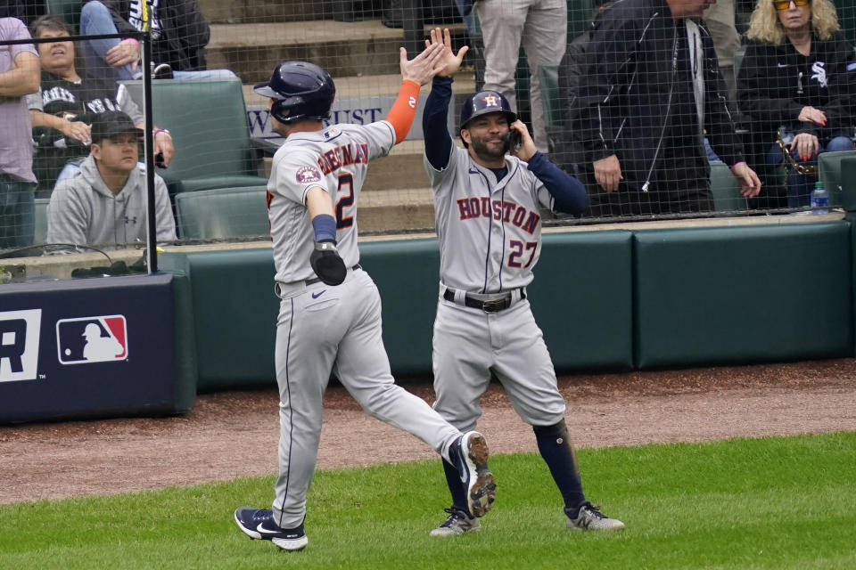 Houston Astros' Alex Bregman (2) and Jose Altuve (27) celebrate scoring on a Carlos Correa double against the Chicago White Sox in the third inning during Game 4 of a baseball American League Division Series Tuesday, Oct. 12, 2021, in Chicago. (AP Photo/Charles Rex Arbogast)