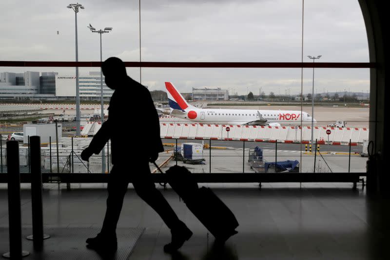 FILE PHOTO: A man walks through a terminal at Paris Charles de Gaulle airport near Paris