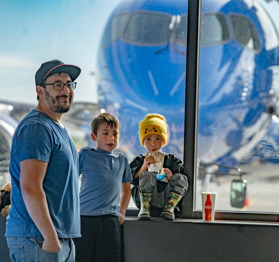 Travis Hoki and his sons Milo, 7 years old and Max, 3 years old, of Pleasant Grove, Utah wait in the terminal for the call to board the airplane. Max has autism. Breeze Airways hosted an exercise for people with autism, ages 3-20, to experience the process of airplane procedures to make future travel easier.