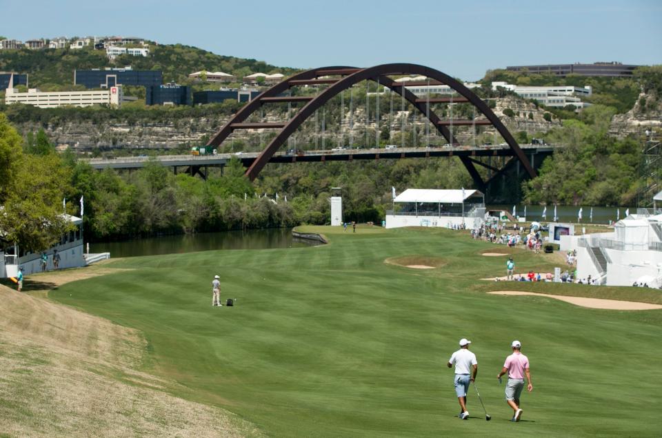 Tiger Woods and Bryson DeChambeau walk the fairway of the iconic 12th hole of the Austin Country Club during a practice round for the 2019 Dell Match Play tournament. No. 12, with the Pennybacker Bridge looming in the background, is one of the tournament's iconic holes.