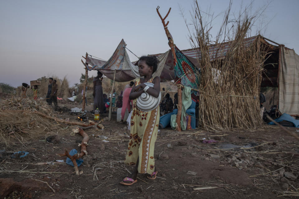 A Tigray girl who fled the conflict in Ethiopia's Tigray region, walks near her shelter in Umm Rakouba refugee camp in Qadarif, eastern Sudan, Wednesday, Nov. 25, 2020. Misery continues for the refugees in Sudan, with little food, little medicine, little shelter, little funding and little or no contact with loved ones left behind in Tigray. (AP Photo/Nariman El-Mofty)