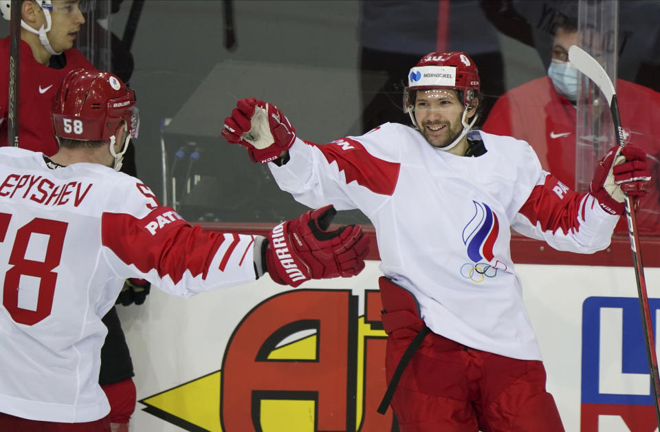 Sergei Tolchinski, right, and Anton Slepyshev of Russia celebrate during the Ice Hockey World Championship group A match between the Switzerland and Russia at the Olympic Sports Center in Riga, Latvia, Saturday, May 29, 2021. (AP Photo/Roman Koksarov)